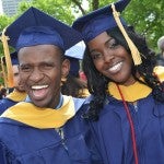 Two students pose with smiles after graduating