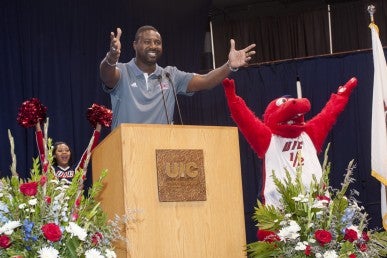 Men’s basketball head coach Howard Moore and Sparky D. Dragon at convocation.