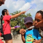 April Rahman helps her son, Wage, blow bubbles