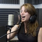 young woman singing at a recording studio