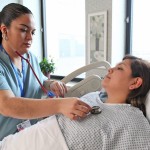 nurse using stethoscope on patient's chest