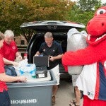 Freshman Daniel Stewart gets a hand from the Amiridis', Susan Teggets, Director of Campus Housing and Sparky.