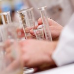 view of hands among chemistry glassware