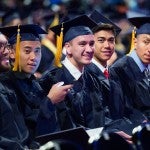 graduates seated, smiling