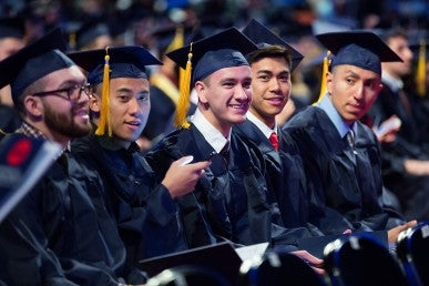 graduates seated, smiling