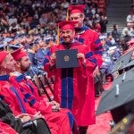 Master's student holding his degree