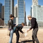 students cleaning up trash on a beach