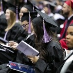 student reading commencement program