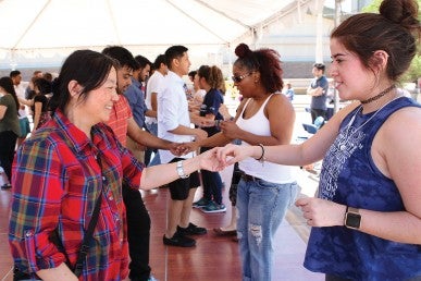 students, facutly, and staff learning dance moves