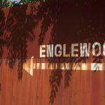 Fence with "Englewood" and an arrow pointing left