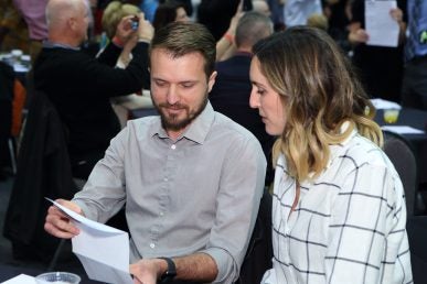 man showing woman his Match results