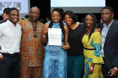 woman with her match letter poses with her family