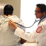 Doctor listening to lung sounds using stethoscope