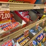 Rows of candy bars in a supermarket checkout lane.