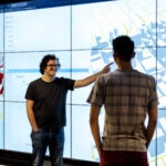 Fabio Miranda is an Assistant Professor at the Department of Computer Science at the University of Illinois Chicago. He is standing in front to a code generated map.