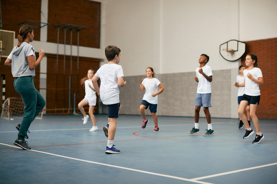A group of kids exercising in a school gym.
