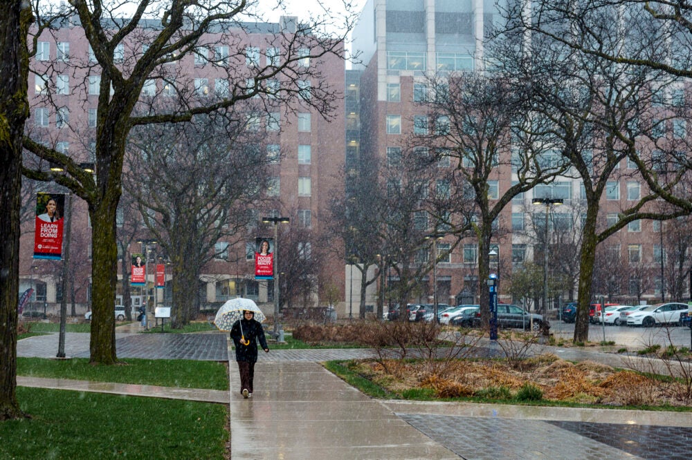 Person walking through the rain on the west side of campus. Photo by Martin Hernandez/UIC