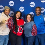 a family poses in front of a UIC backdrop