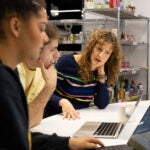 Three people working together at a computer.