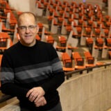 Man in black and gray sweater in an empty lecture hall