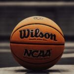 An NCAA-branded Wilson basketball sits on a floor with a grey background.
