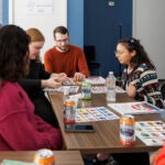 Men and women play a board game