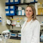 a woman in a white lab coat in a lab