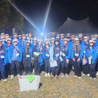 Fifty-one students volunteered to help out at this year's Chicago Marathon on Oct. 13. (Photo: Michele Kerulis and Meredith Wekesser) A large group of students in blue jackets in the early morning before the Chicago Marathon starts.