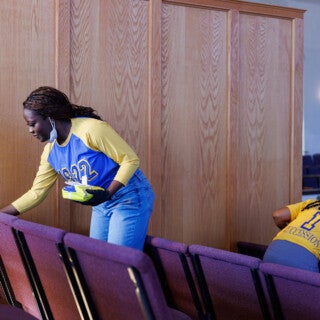 For the 2025 MLK Jr. Day of Service, UIC students cleaned and picked up trash at Stone Temple Baptist Church in Lawndale. (Photo: Creative and Digital Services) two students clean chairs at a church